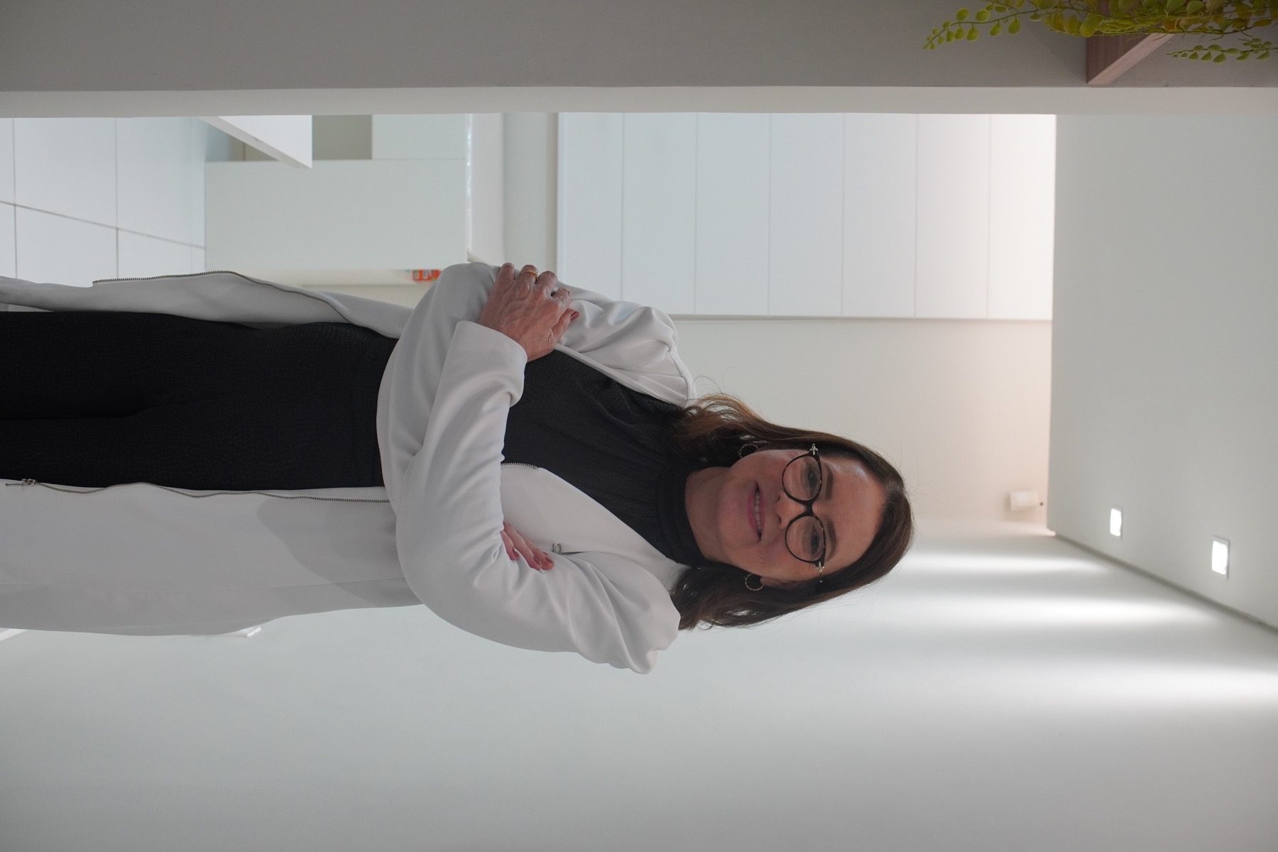 Dra. Flávia Pimenta usando jaleco branco no consultório